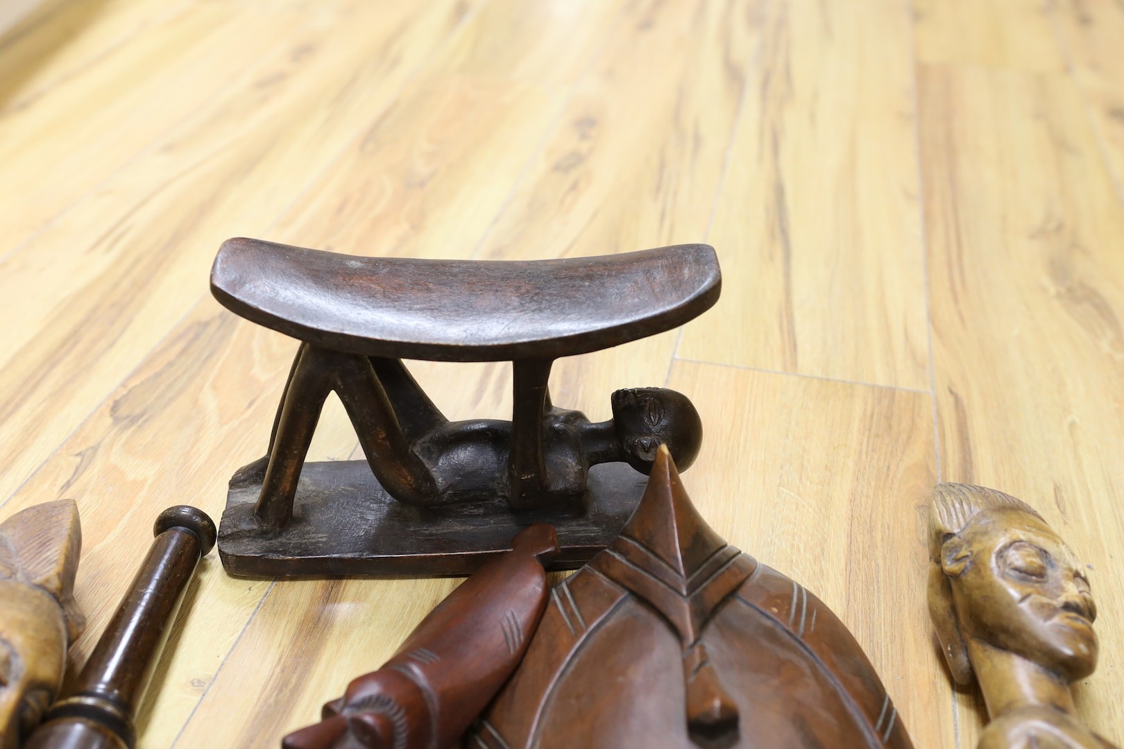 A group of African hardwood carvings, shell and beadwork including a cap
